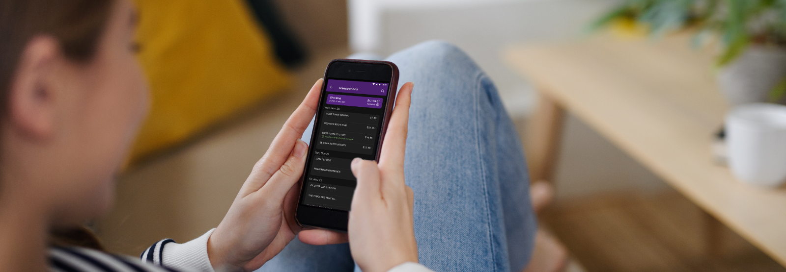 Young woman looking at her HomePride Bank app on her smartphone.