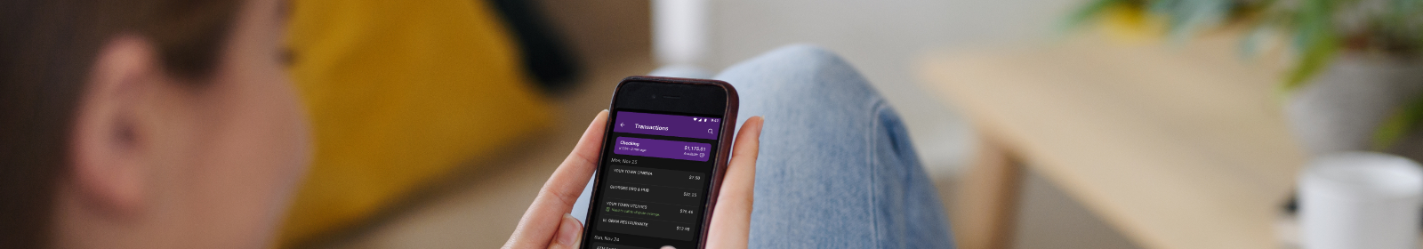 Young woman looking at HomePride Bank app on smartphone